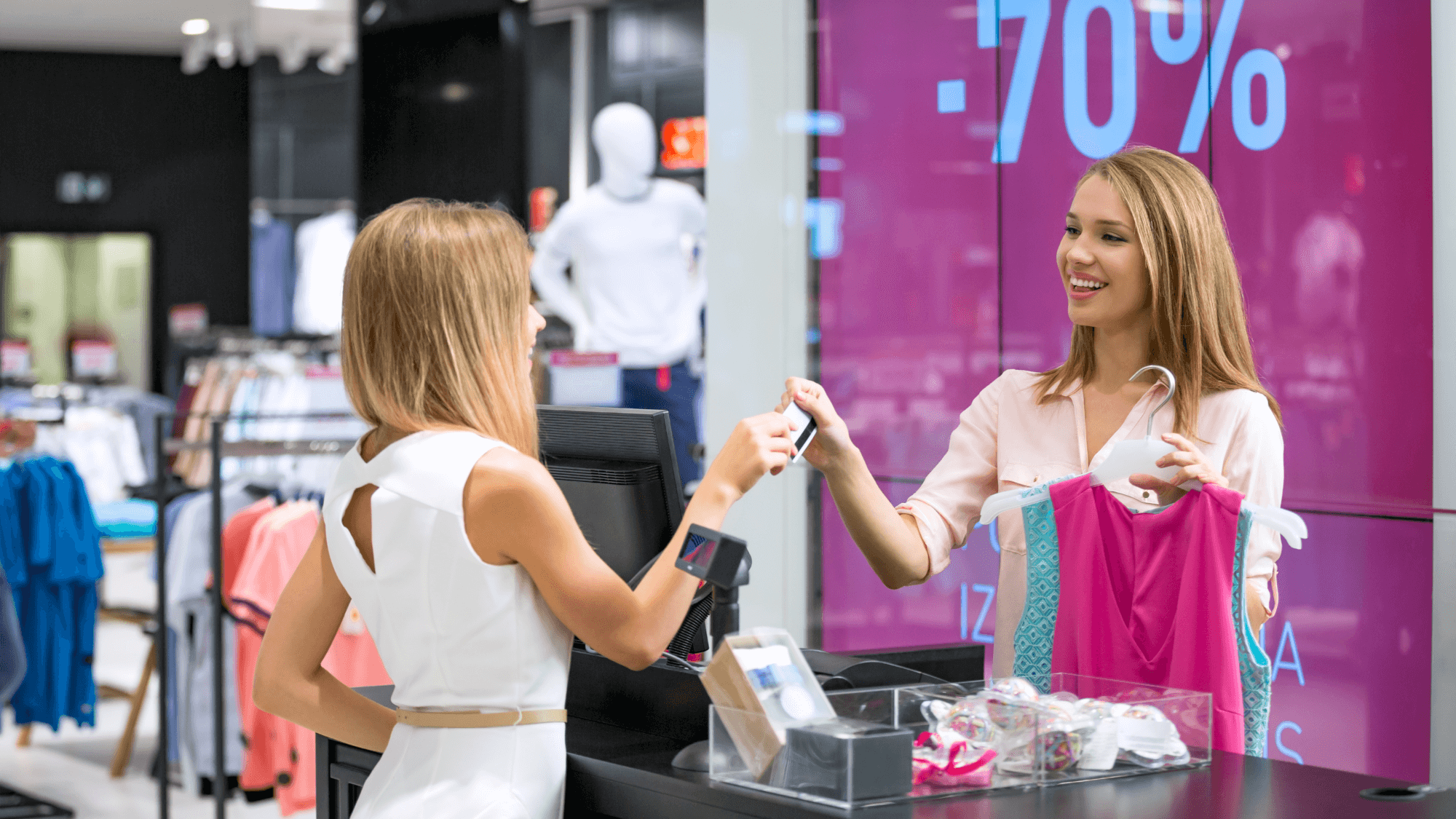 a woman buying clothing at a shop in a mall